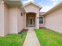 Inviting home entrance with a covered porch, stylish door, and green grass at 26301 Sackamaxon Dr, Sorrento, FL 32776
