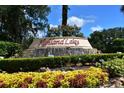 Welcoming entrance to Highland Lakes featuring colorful landscaping and a charming water feature at 26535 Deuce Ct, Leesburg, FL 34748