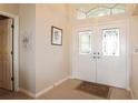 Bright foyer showcasing tiled floors, a decorative double-door entrance, and neutral paint at 27024 Old English Ct, Leesburg, FL 34748