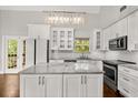 Bright, updated kitchen featuring white cabinets, modern appliances, and a marble countertop island at 2870 Belinda Dr, Deland, FL 32720