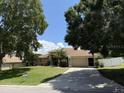 Home exterior featuring a long driveway, attached garage, and well-maintained landscaping at 3030 Brighton Rd, Eustis, FL 32726