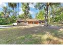 Charming home featuring a stone facade, complemented by lush landscaping and mature trees at 400 Sw 35Th St, Ocala, FL 34471