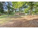 Spacious front yard with mature trees, showcasing the home's inviting exterior and ample outdoor space at 400 Sw 35Th St, Ocala, FL 34471