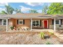 Welcoming front porch with seating, complemented by potted plants and a bright red door at 400 Sw 35Th St, Ocala, FL 34471