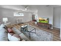 Bright living room features hardwood floors, stylish furniture and flows to the kitchen and dining area at 412 Sunny Ct, Fruitland Park, FL 34731