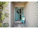 Inviting front entrance featuring a vibrant blue door with decorative wreath and chair at 419 Aldama Ave, The Villages, FL 32159