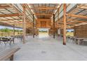 Spacious barn interior featuring a metal roof, wooden beams, tables and wagon wheel accents at 4635 Brantley Rd, Groveland, FL 34736