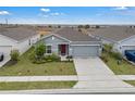 An elevated view of a charming single-story home with a well-manicured lawn and a two-car garage at 4905 Vellacito Way, Davenport, FL 33897