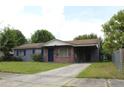 Charming single-story home features a brick and gray painted exterior, an open carport, and a well-maintained front lawn at 5177 Edwina St, Orlando, FL 32811