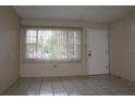 Bright living room with tile floors, large window, and white front door creating an inviting space at 5177 Edwina St, Orlando, FL 32811