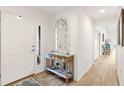 Bright entryway with a decorative mirror and wooden floors, creating a warm and welcoming atmosphere at 5726 Leboeuf Ln, The Villages, FL 32163