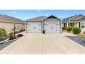This home features a spacious two-car garage and concrete driveway, complemented by tasteful landscaping at 5726 Leboeuf Ln, The Villages, FL 32163