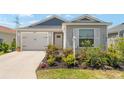 Charming single story home with blue and gray accents, attached garage, and manicured landscaping at 6342 Whittle Ct, The Villages, FL 32163
