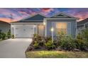 Charming single story home with blue and gray accents, attached garage, and manicured landscaping at 6342 Whittle Ct, The Villages, FL 32163
