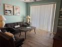 Cozy living room with wood floors, a ceiling fan, and ample natural light at 8815 Dunes Ct # 105, Kissimmee, FL 34747