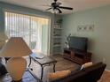 Living area featuring wood floors, ceiling fan, and sliding doors to a patio at 8815 Dunes Ct # 105, Kissimmee, FL 34747