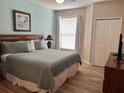 Bedroom featuring a king size bed, wood-look floors, and a large window at 8815 Dunes Ct # 105, Kissimmee, FL 34747