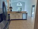 Bright kitchen featuring stainless steel appliances, white cabinets, and views into the living area at 1040 Soaring Eagle Ln, Kissimmee, FL 34746