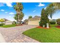 Charming single-story home with brick-paved driveway, lush lawn, and well-manicured landscaping in a friendly neighborhood at 10460 Silver Maple Ave, Oxford, FL 34484