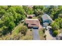 Birds-eye view of single-story home with a long driveway and lush landscaping on a sunny day at 12110 Palmetto Ct, Dunnellon, FL 34432