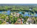Aerial view showcasing a neighborhood nestled among lush trees along a scenic waterway at 12110 Palmetto Ct, Dunnellon, FL 34432