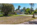 Charming home exterior featuring a well-maintained lawn, mature trees and long driveway at 12110 Palmetto Ct, Dunnellon, FL 34432