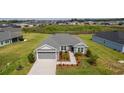 Beautiful aerial view of a gray single-story home with manicured landscaping in a peaceful neighborhood at 1422 Jeremy Cir, The Villages, FL 34762