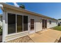 Rear exterior view with sliding glass doors and a concrete patio at 1706 Moreno Pl, The Villages, FL 32159