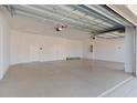 Spacious and well-lit three-car garage featuring epoxy flooring and ample storage space and a high ceiling at 1796 Zientara Loop, The Villages, FL 32163