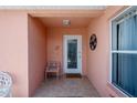 Inviting front porch featuring tiled flooring, decorative wall art, and a charming welcome mat at 1814 Marquez Loop, The Villages, FL 32159
