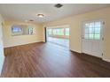Open-concept living room with hardwood floors and a view of the enclosed patio at 2037 Lakeshore Dr, Mount Dora, FL 32757