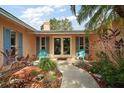 Inviting front entrance with a pathway, chairs, and lush tropical landscaping at 2121 Suzanne Dr, Mount Dora, FL 32757