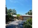 Beautiful single Gathering home featuring a long driveway, lush landscaping, and an attached garage at 2121 Suzanne Dr, Mount Dora, FL 32757