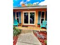 Charming front porch with seating and blue shutters framing the door of this single Gathering home at 2121 Suzanne Dr, Mount Dora, FL 32757