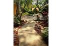 A walkway leads through a white picket fence to the front door surrounded by lush landscaping at 2121 Suzanne Dr, Mount Dora, FL 32757