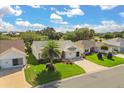 An aerial view shows the property's lush green lawn, mature landscaping, and neighborhood setting at 2204 Margarita Dr, The Villages, FL 32159