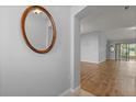 The foyer features wood flooring and a decorative mirror that adds charm and complements the interior's design at 2204 Margarita Dr, The Villages, FL 32159