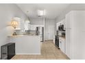 Bright kitchen featuring stainless steel appliances, white cabinetry, and tile flooring at 2204 Margarita Dr, The Villages, FL 32159