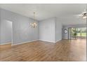 Spacious living room with vaulted ceilings, a chandelier, wood floors, and sliding doors to the outdoors at 2204 Margarita Dr, The Villages, FL 32159