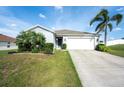 Single-story home featuring a two-car garage, green lawn, and a well-maintained front yard at 2256 Gladiolus Ln, Mascotte, FL 34753