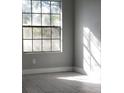 Well-lit room featuring a large window, gray tile flooring, and neutral gray walls at 234 Afton Sq # 205, Altamonte Springs, FL 32714