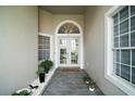 Inviting entryway with double doors, tile flooring, and decorative plants. 