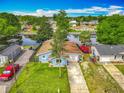 Charming light blue waterfront home featuring a well-manicured lawn, mature trees, and a private dock at 26619 Bimini Dr, Tavares, FL 32778