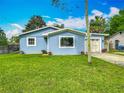 Charming blue single-story home with well-maintained lawn and attached two-car garage at 26619 Bimini Dr, Tavares, FL 32778