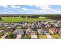 An aerial view of a suburban neighborhood with a beautiful home and expansive green space at 3354 Truluck Pl, Oxford, FL 34484