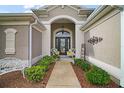 Inviting front entrance featuring a covered porch, decorated door, and landscaped walkway at 3354 Truluck Pl, Oxford, FL 34484