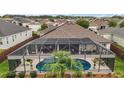 An aerial view of a screened in pool, patio, and lush landscaping in the backyard at 3354 Truluck Pl, Oxford, FL 34484