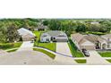 Aerial view of a well-maintained home with a two-car garage and manicured lawn in a serene neighborhood at 3800 Woodleaf Ct, Leesburg, FL 34748