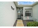 Inviting front entrance with a decorative door, manicured greenery, and stylish wall decor at 3800 Woodleaf Ct, Leesburg, FL 34748