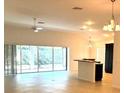 Open-concept living area with a large sliding glass door and modern lighting at 3942 Zenith Loop, The Villages, FL 32163